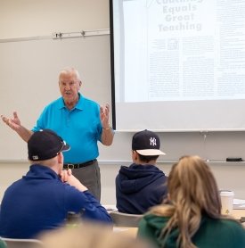 A professor leads a discussion in a full classroom