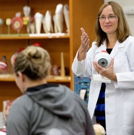 Image of Ann Miele holding a plastic model of an eye