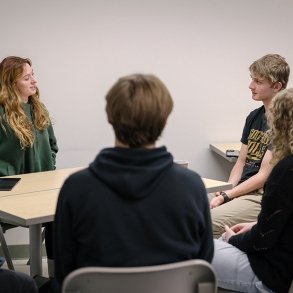 Students talking at collaborative desk in a classroom