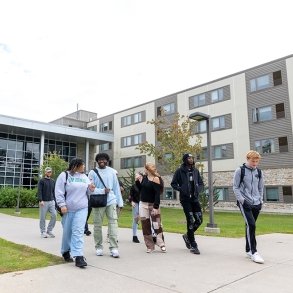 A group of students leaves the Residence Hall together, talking