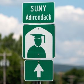 Traffic sign with the words SUNY Adirondack on it and a graphic of a graduate