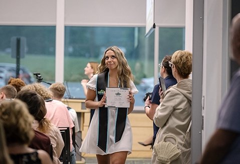 An ECCA graduate collects her certificate at the graduation ceremony