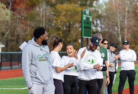 SUNY Adirondack Student Affairs employees celebrate a play during a staff-building Wiffleball game