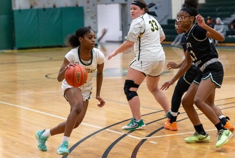 Women's basketball team on the court with the ball