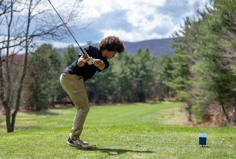 Men's golf athlete teeing up