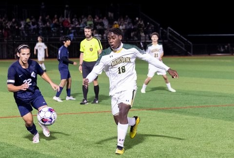 Men's soccer during a night game on the turf field