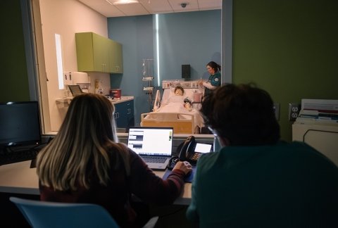 Nursing professors guiding nursing students through a simulation