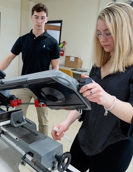 Students working in the mechatronics lab with machine equipment